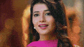 a close up of a woman 's face in a pink dress .