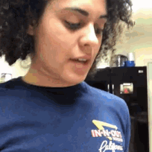 a woman wearing a blue in-n-out california shirt