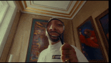 a man holding a magnifying glass in front of a painting that says ' jesus ' on it