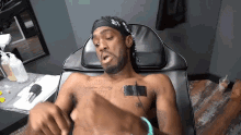 a man is laying in a chair with a tattoo on his chest that says south