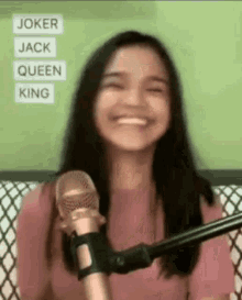a woman is smiling while sitting in front of a microphone .