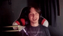 a man is sitting in a chair in front of a microphone .