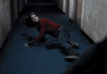 a woman in a red sweater is holding a sword in a dark hallway .