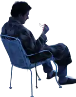 a man in a robe is sitting in a chair looking down