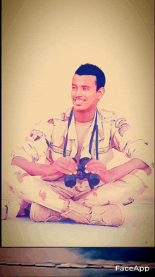 a man in a military uniform sits with his legs crossed holding binoculars