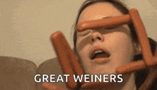 a woman is holding hot dogs in front of her face and the words great weiners are above her