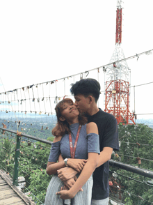 a man kisses a woman on the forehead while wearing a lanyard that says ' tnt '