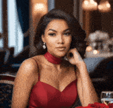 a woman in a red dress is sitting at a table with a glass of wine