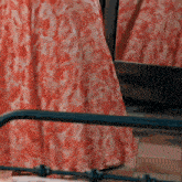 a woman in a red dress is standing next to a mirror