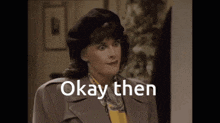 a woman wearing a beret and a jacket says " okay then "
