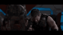 a man with a beard is standing in a dark room holding a gun .