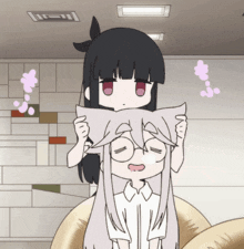 a girl with black hair is holding a white pillow over another girl 's head