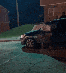 a blurry picture of a car driving down a street at night with a building in the background .