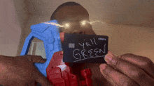 a man is holding a credit card that says y'all green on it