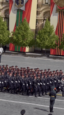 a group of soldiers march down a street in front of a building