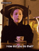 a woman is sitting at a table with a cup of tea and says how did you do that