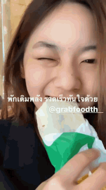 a woman eating a subway sandwich with a caption that says @grabfoodth