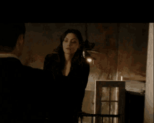 a woman in a black dress stands next to a man