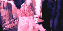 a woman with pink hair and a feathered headpiece