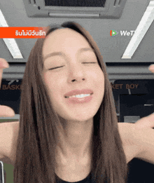 a woman is smiling with her eyes closed in front of a wetv logo