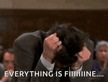 a man in a suit is scratching his head while a group of people are watching .