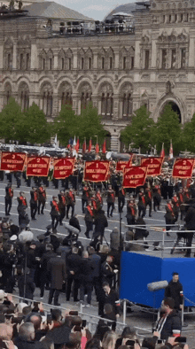 a crowd of people watching a parade with flags that say 1 2 and 3 on them