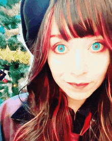a woman with blue eyes and red hair looks at the camera