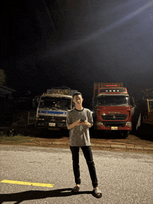 a man stands in front of a row of trucks one of which has the word heavy on the front
