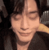 a close up of a person 's face with their eyes closed and a smile on their face .