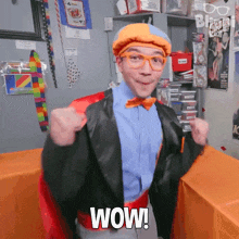 a man in a superhero costume has the word wow written on his chest