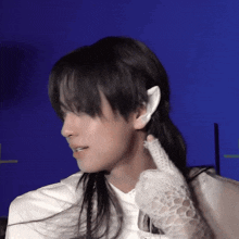 a close up of a person 's face with a white glove on