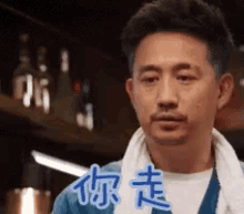 a man with a towel around his neck is making a funny face in a restaurant .