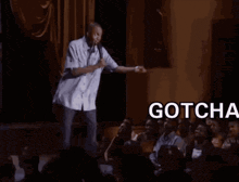 a man is giving a speech in front of a crowd and the words gotcha bitch are above him