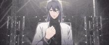 a man with long hair and a turtleneck is standing in a dark room .