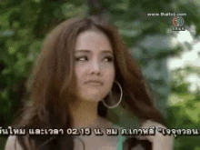 a woman wearing hoop earrings is looking up at the sky