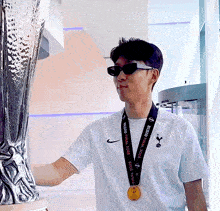 a man wearing sunglasses and a medal that says final 2020 on it