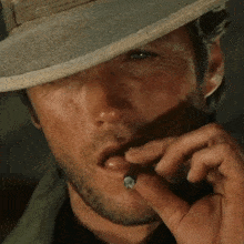 a man wearing a hat is smoking a cigar in his mouth