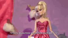 a barbie doll in a pink dress is talking to another doll .