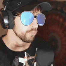 a man wearing sunglasses and headphones is wearing a hat that says ck on it