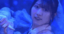 a close up of a woman 's face with blue lights behind her