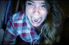 a woman in a plaid shirt is wearing headphones