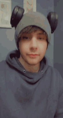 a young man wearing a beanie with headphones on his ears