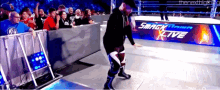 a smackdown live sign is behind a man