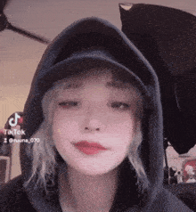 a girl wearing a hat and a hoodie with tiktok written on the bottom