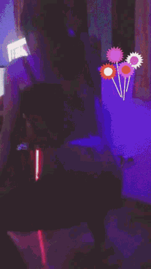 a woman in a green top and black pants is dancing with an orange flower behind her