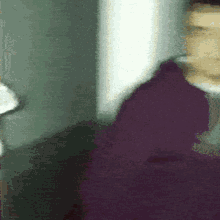 a blurry picture of a person wearing a purple sweater