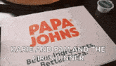 a papa john 's menu is sitting on a table next to a pizza and garlic sauce .