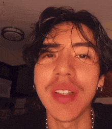a close up of a man 's face with a nose ring and earrings