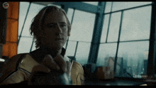 a man in a superhero suit is standing in front of a large window .