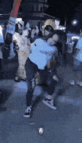 a man in a white shirt is dancing in a crowd of people